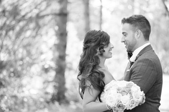 couple embracing in the park in black and white with a bouquet