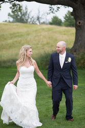 bride and groom walking hand in hand in park