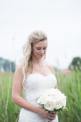 bride looking at her bouquet in park