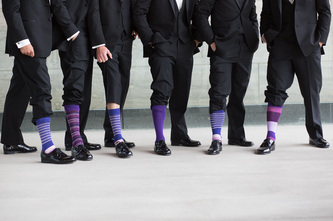 groomsmen hiking up pants to expose purple socks