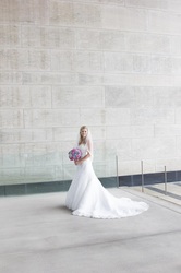 bride holding bouquet in front of stone wall