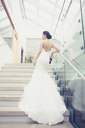  glamorous pose of asian bride’s back on glass staircase