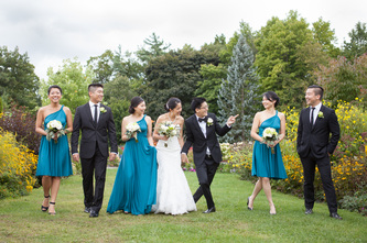 bridal wedding party with teal dresses and black suits