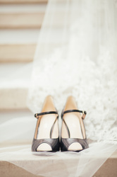 bridal shoes with the wedding dress in the background