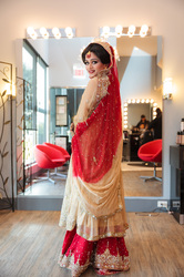 indian bride wearing a red wedding outfit posing in a hair salon