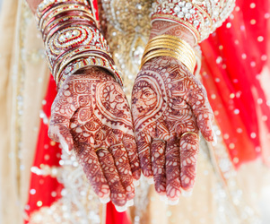 vibrant scene of bride’s hands covered in henna from mehndi ceremony