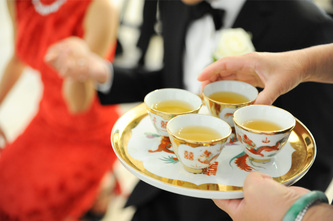 close up of tea cups being served during wedding tea ceremony