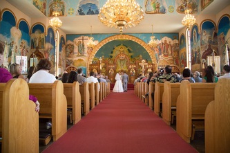 bride and groom walking down isle in ukranian orthodox church