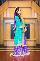 pakistani bride posing in teal orange and blue wedding dress