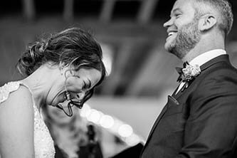 black and white photo of bride and groom laughing during the wedding ceremony at twist gallery queen street west Toronto