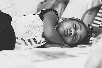 daugther sleeping on the bed while mom the bride was getting ready